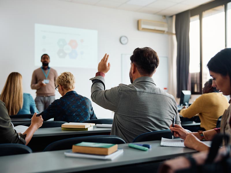 main raising hand in classroom