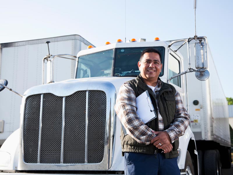 man standing in front of commercial truck after completing CDL course